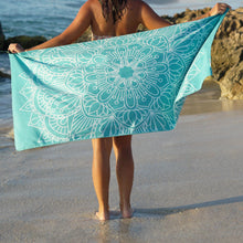 Load image into Gallery viewer, woman standing on shore with arms outstretched holding turquoise towel with mandala print